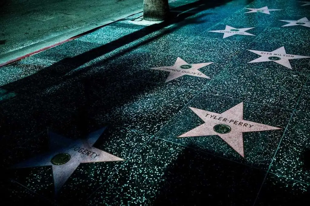 El Paseo de la Fama de Hollywood por la noche, destacando las estrellas en el suelo con nombres de celebridades bajo la luz tenue